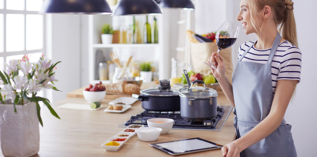 une femme dans la cuisine buvant un verre de vin